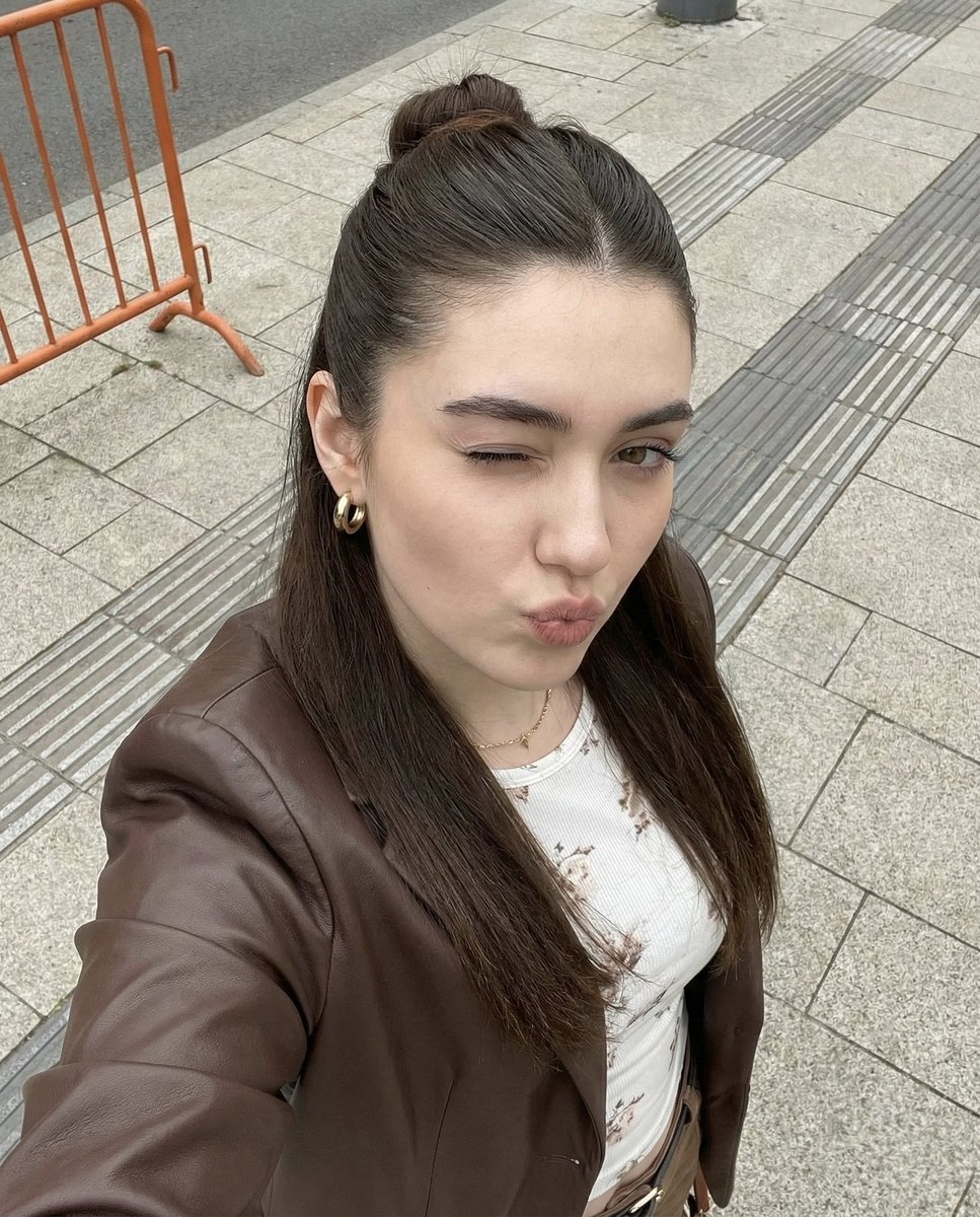 Playful Young Woman Selfie: Brown Jacket & Floral Top Nano Banana提示词