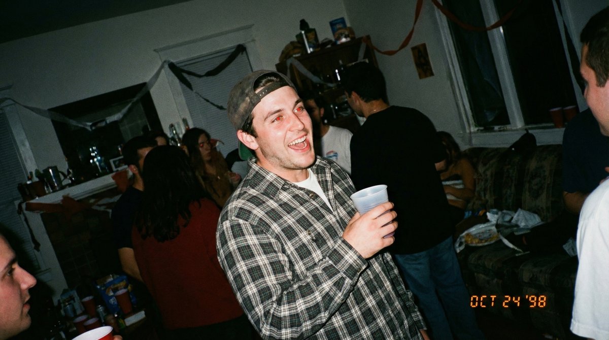 Candid 90s Party Photo | Young Man Laughing, Red-Eye Nano Banana提示词