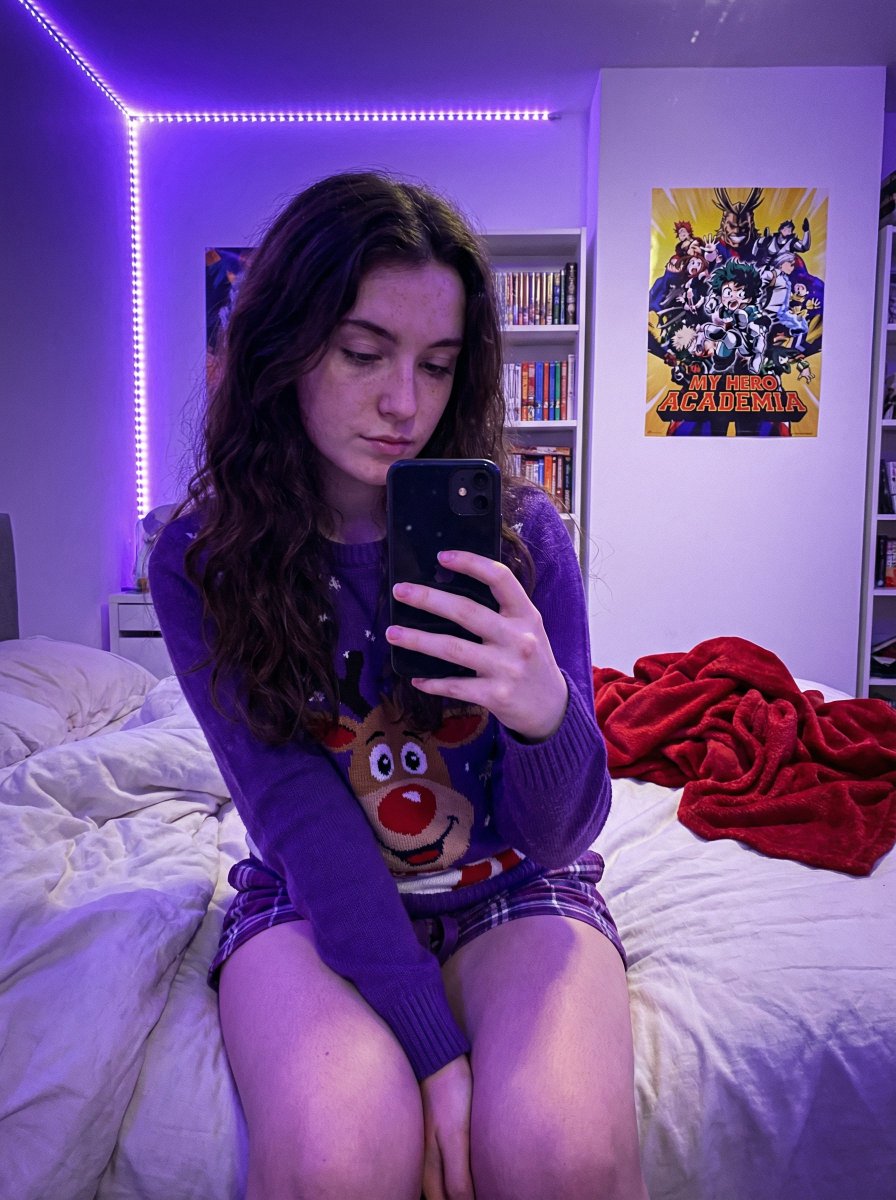 Young Woman's Cozy Bedroom Selfie in Christmas Sweater Nano Banana提示词